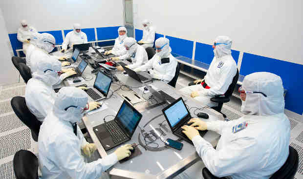 Intel operations leaders gather for the daily "8:20" – a morning huddle inside Fab D1X to ensure that the Hillsboro, Oregon, chip factory is running smoothly. Up to 30 people may squeeze into this room to confer on factory tool status, parts availability, operating forecasts, experts who may be needed or other urgent issues. The fab – the size of four football fields – runs 24/7/365. (Credit: Walden Kirsch/Intel Corporation)