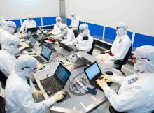 Intel operations leaders gather for the daily "8:20" – a morning huddle inside Fab D1X to ensure that the Hillsboro, Oregon, chip factory is running smoothly. Up to 30 people may squeeze into this room to confer on factory tool status, parts availability, operating forecasts, experts who may be needed or other urgent issues. The fab – the size of four football fields – runs 24/7/365. (Credit: Walden Kirsch/Intel Corporation)