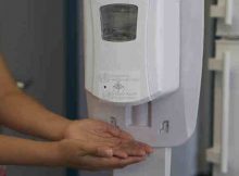 A health worker sanitizes her hands before putting on a mask. Photo: WHO